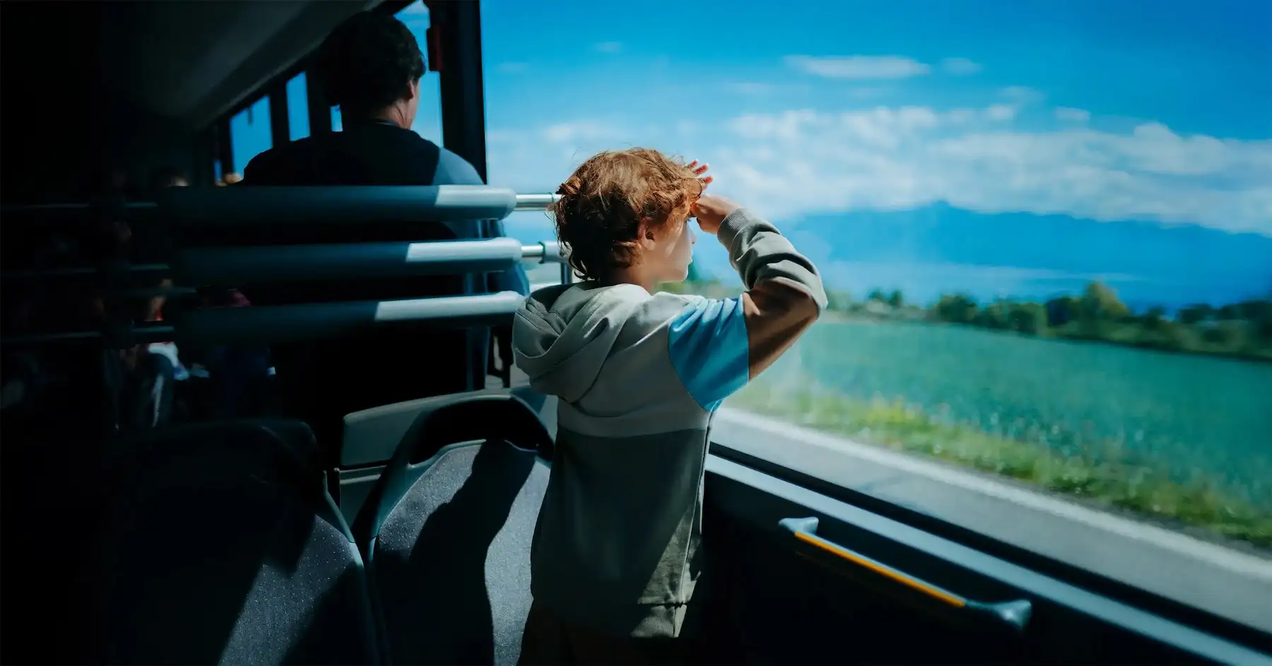 Enfant regarde paysage par la fenêtre du bus.